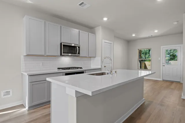 a kitchen with a sink stove and microwave
