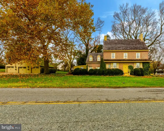 a view of a house with a yard and large trees