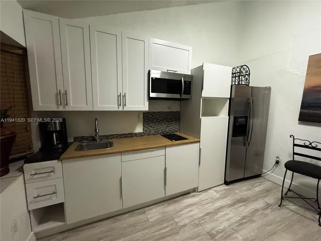 a kitchen with stainless steel appliances granite countertop a stove a refrigerator and a microwave