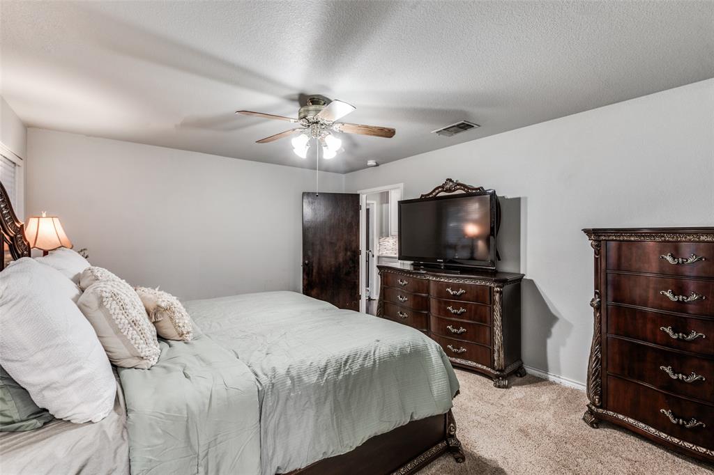 131 Cunningham Road Denton, TX 76208 - Photo 16 of 40 a bedroom with a bed and a flat screen tv