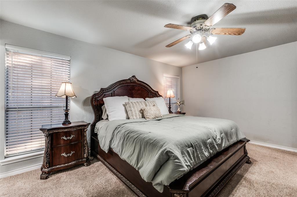 131 Cunningham Road Denton, TX 76208 - Photo 18 of 40 a bedroom with a bed and a chandelier