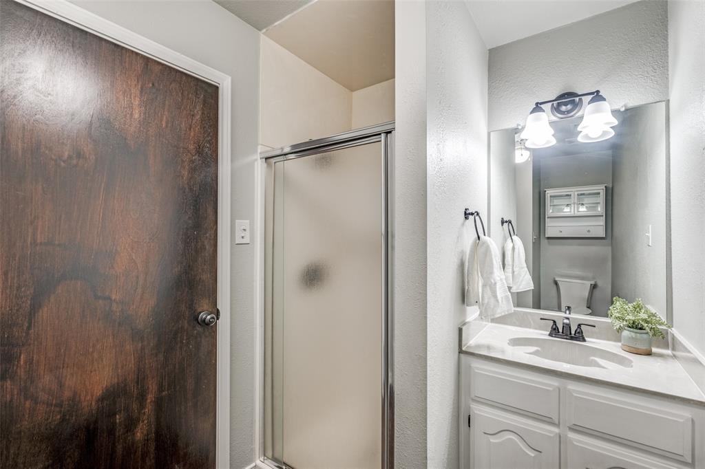 131 Cunningham Road Denton, TX 76208 - Photo 20 of 40 a bathroom with a granite countertop sink a mirror and a shower