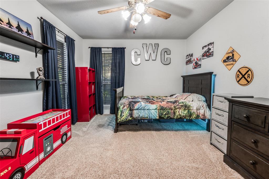 131 Cunningham Road Denton, TX 76208 - Photo 22 of 40 a bedroom with bed and paintings on the wall