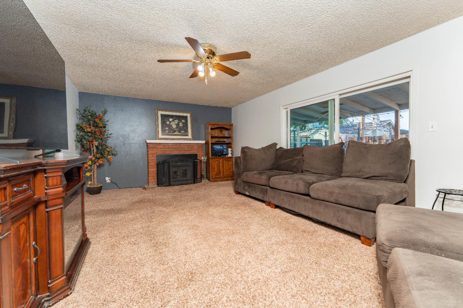 1574 Bluejay Circle Hanford, CA 93230 - Photo 4 of 23 a living room with furniture a chandelier and a fireplace
