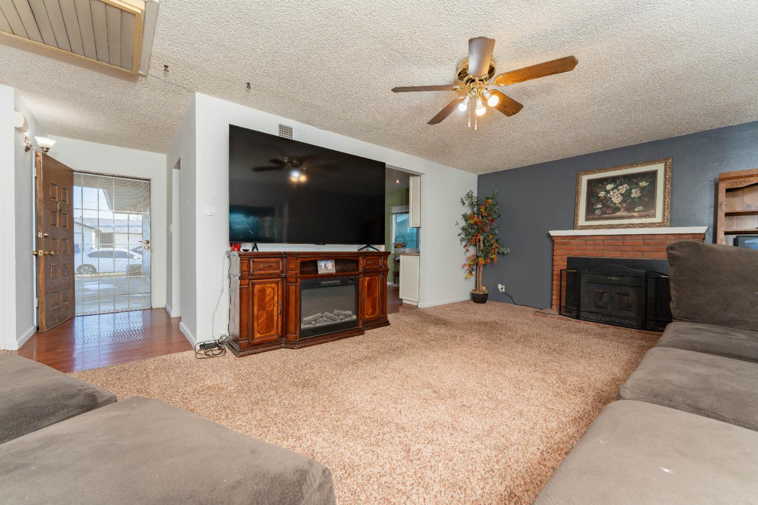 1574 Bluejay Circle Hanford, CA 93230 - Photo 5 of 23 a living room with fireplace and a flat screen tv