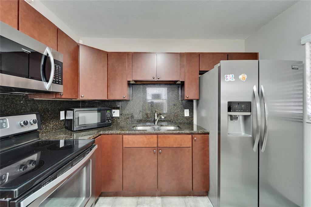 126 Ridgewood Avenue Brandon, FL 33510 - Photo 30 of 85 a kitchen with stainless steel appliances granite countertop a refrigerator and a stove