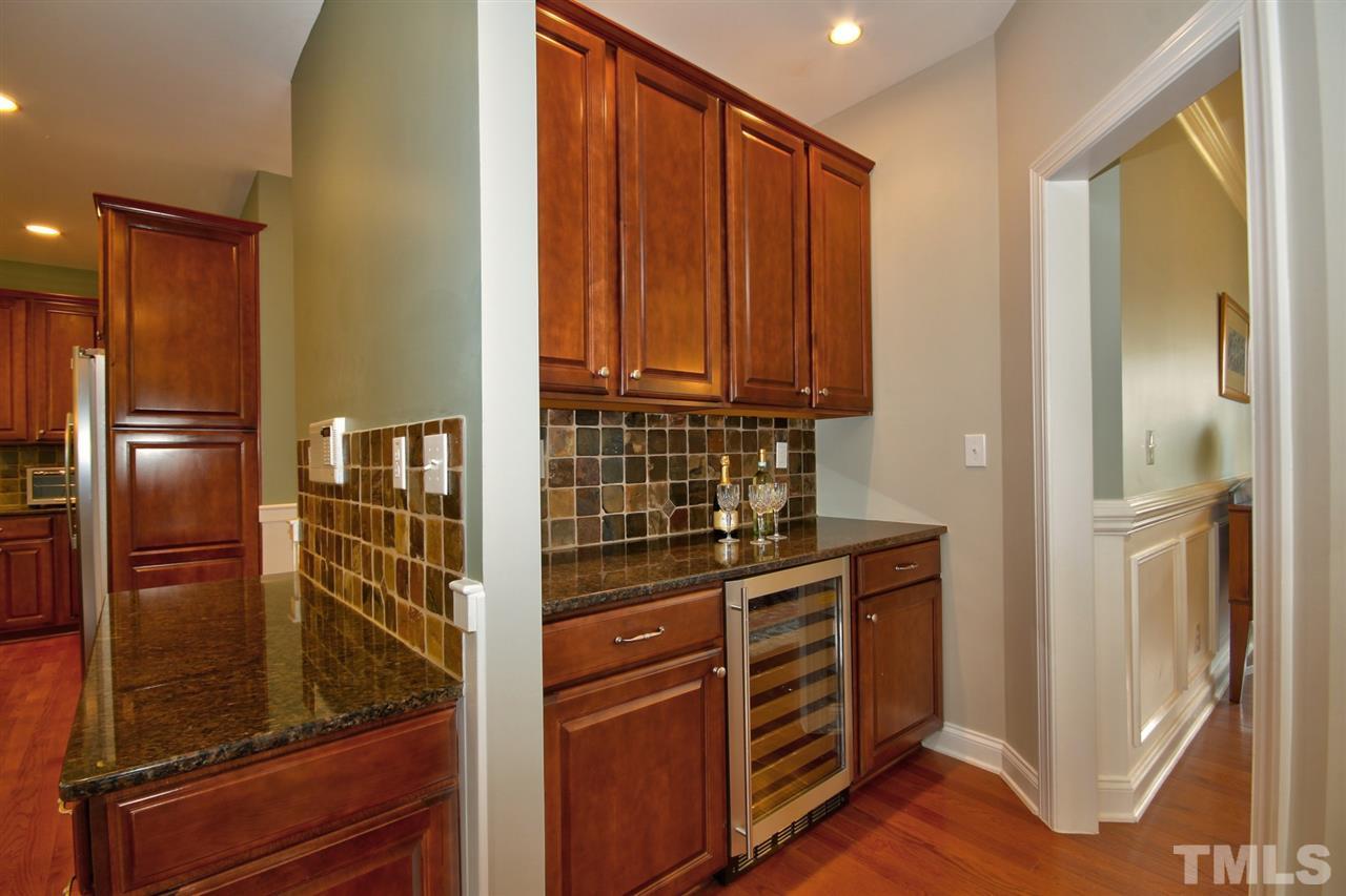 209 Bridle Boast Road Cary, NC 27519 - Photo 14 of 25 a kitchen with wooden cabinets and a refrigerator