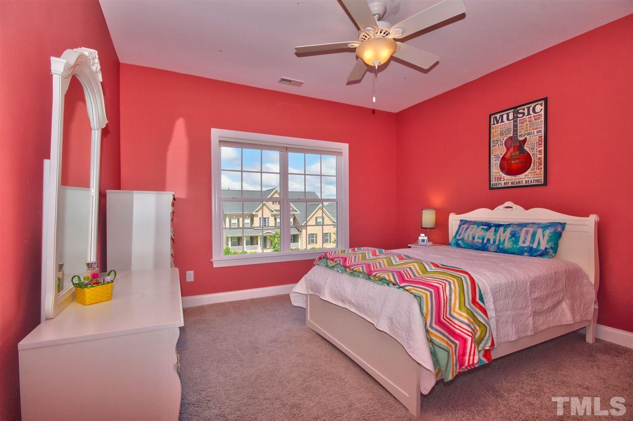 209 Bridle Boast Road Cary, NC 27519 - Photo 19 of 25 a bedroom with a bed and a chandelier