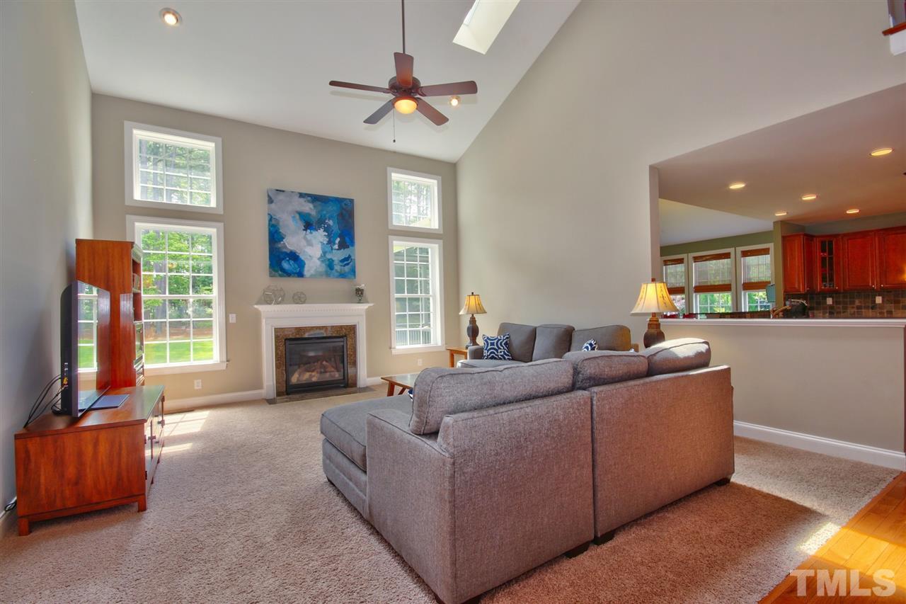209 Bridle Boast Road Cary, NC 27519 - Photo 9 of 25 a living room with furniture a fireplace and a flat screen tv