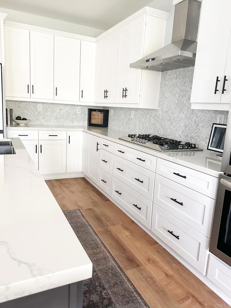 29824 Talitha Way Murrieta, CA 92563 - Photo 9 of 27 a kitchen with stainless steel appliances white cabinets and a sink