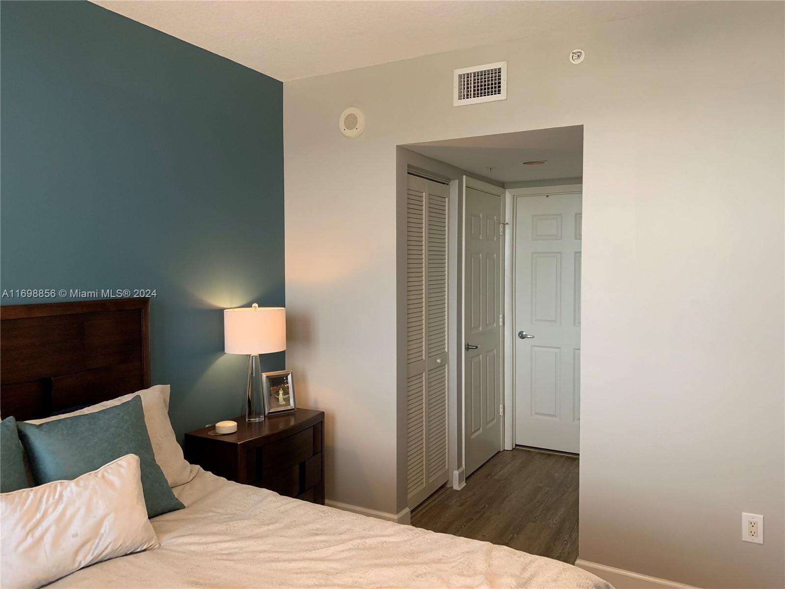 55 Merrick Way, Unit 730 Coral Gables, FL 33134 - Photo 14 of 23 a bedroom with a bed and a lamp