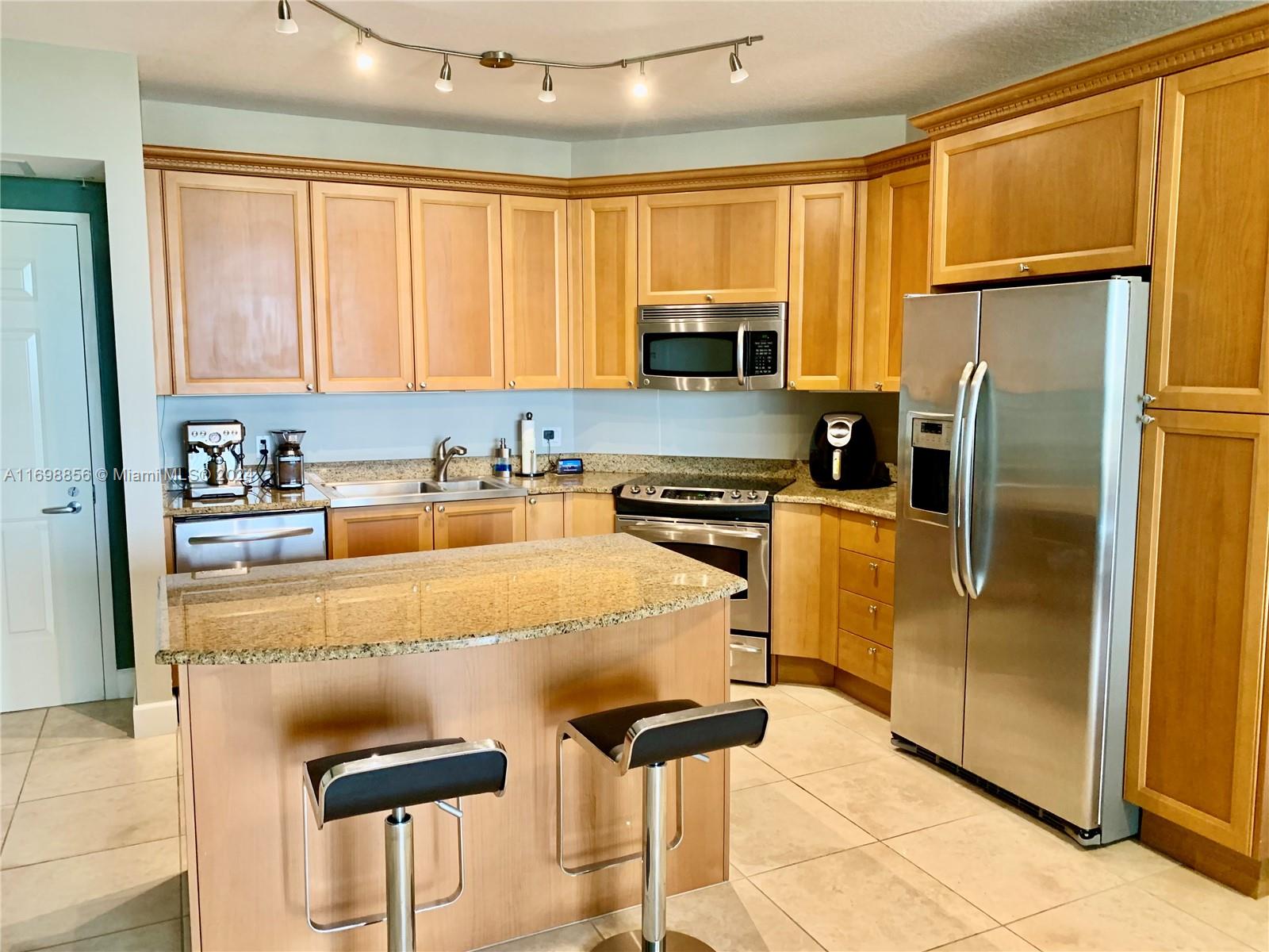 55 Merrick Way, Unit 730 Coral Gables, FL 33134 - Photo 3 of 23 a kitchen with stainless steel appliances granite countertop a refrigerator and a stove top oven