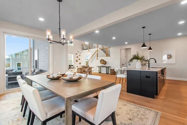 a view of a dining room and livingroom with furniture wooden floor a chandelier
