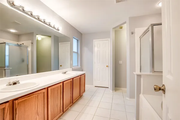 a spacious bathroom with a double vanity sink mirror and shower