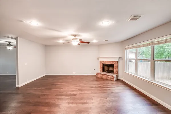 a view of a livingroom with a fireplace a chandelier and wooden floor