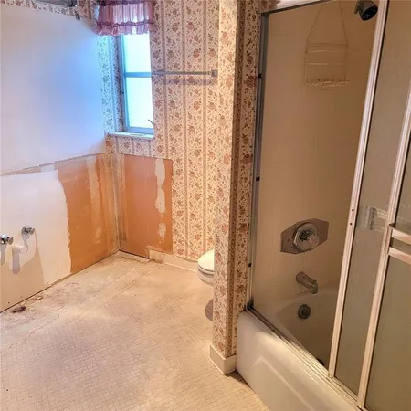 a bathroom with a tub shower and a sink