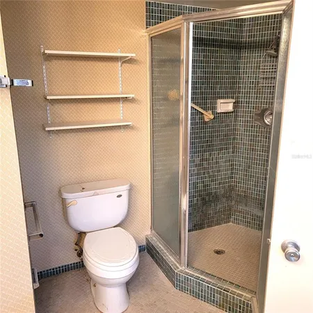 a bathroom with a toilet and a shower
