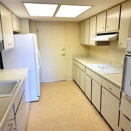 a kitchen with a sink a stove and cabinets