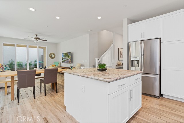 106 Mongoose Irvine, CA 92618 - Photo 5 of 23 a kitchen with stainless steel appliances granite countertop a refrigerator a sink dishwasher a stove and a dining table with wooden floor