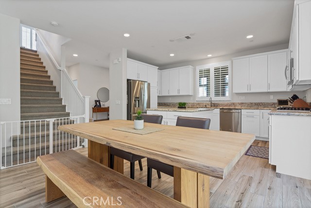 106 Mongoose Irvine, CA 92618 - Photo 7 of 23 a kitchen with stainless steel appliances granite countertop a stove a sink a refrigerator white cabinets and wooden floor