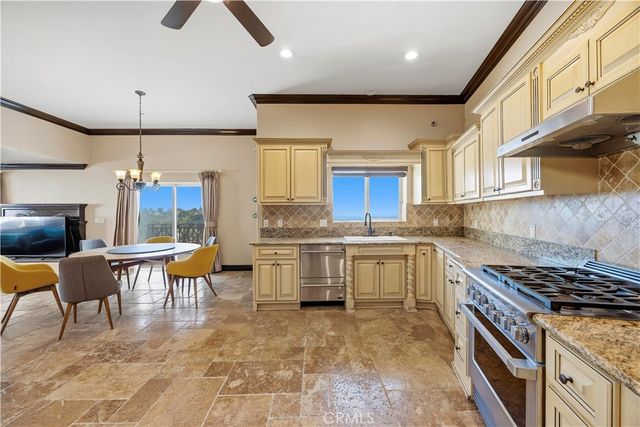 a kitchen with granite countertop a stove a sink and a refrigerator