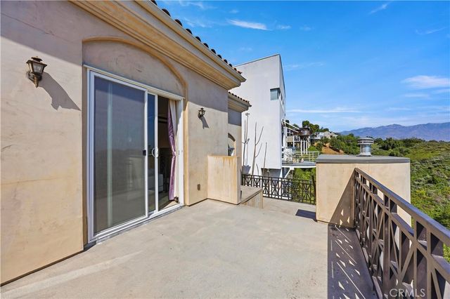 a view of a balcony with furniture and a floor to ceiling window