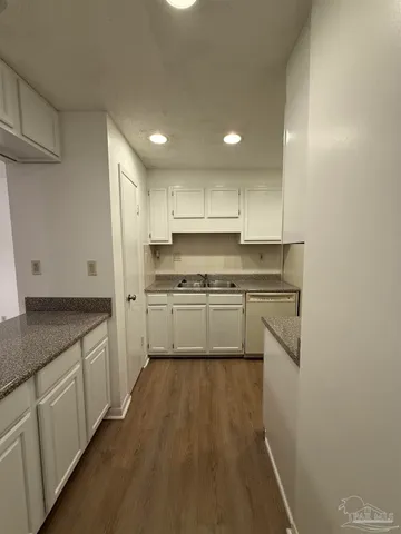 a kitchen with granite countertop white cabinets and white appliances