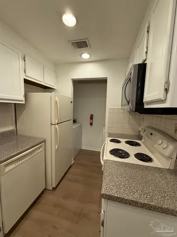 a kitchen with granite countertop a sink a refrigerator and cabinets