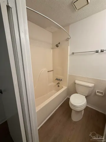 a white toilet sitting next to a bath tub