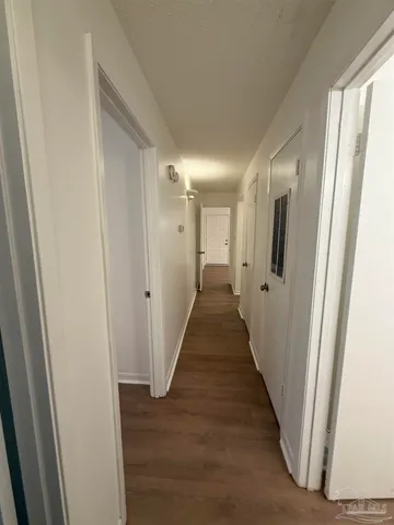 a view of a hallway with wooden floor