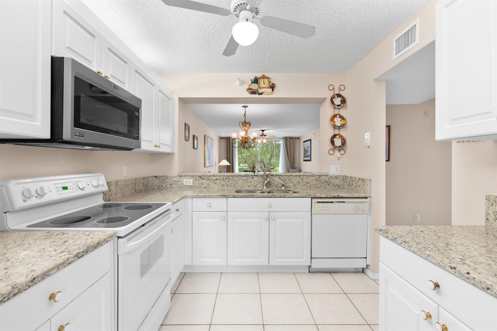 a kitchen with granite countertop a sink and a stove top oven