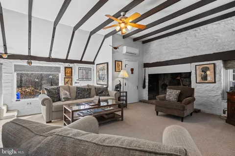 a living room with furniture a wooden floor and floor to ceiling window
