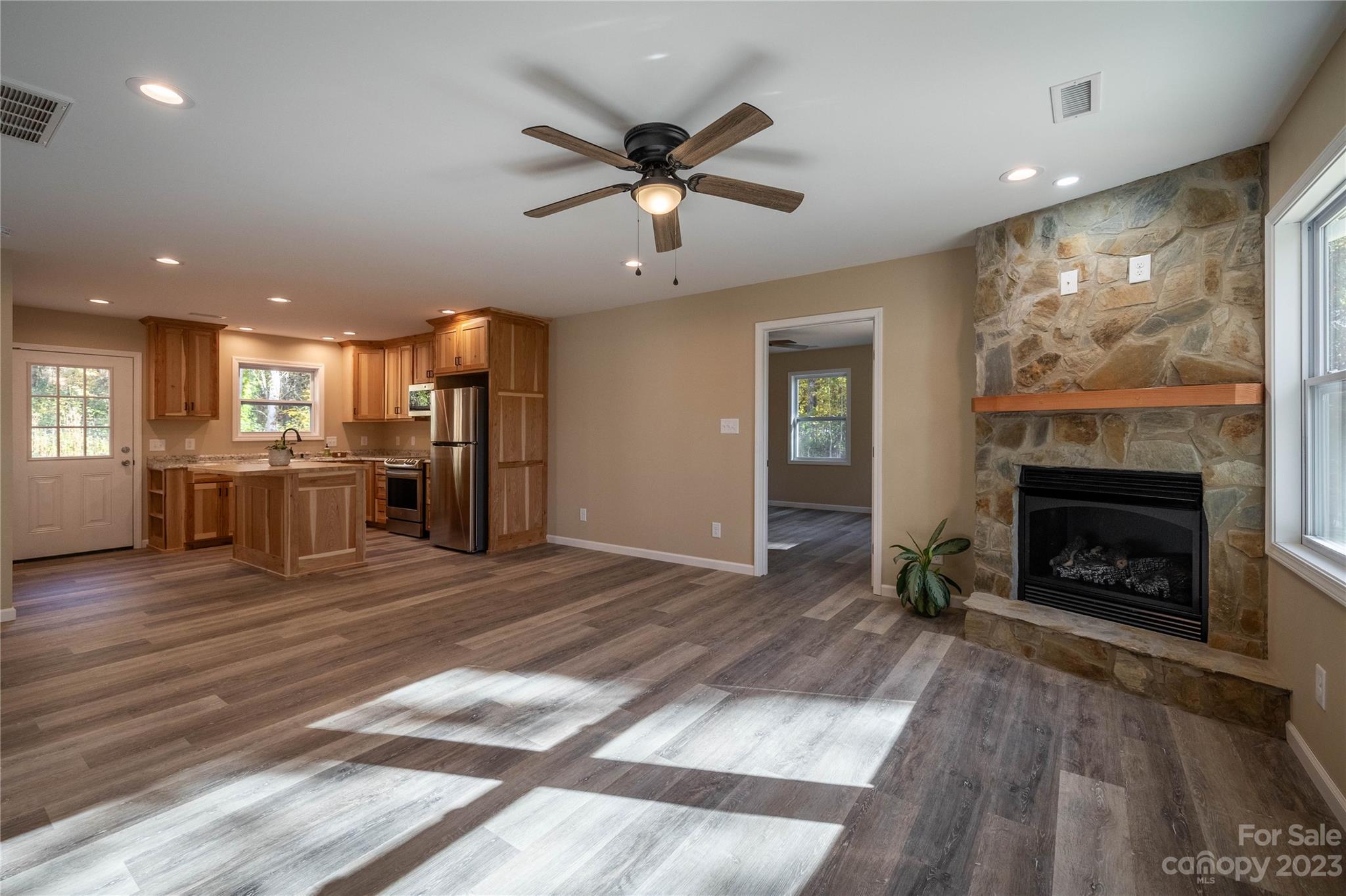 1237 Coffey Road Morganton, NC 28655 - Photo 4 of 19 an empty room with wooden floor a fireplace and windows