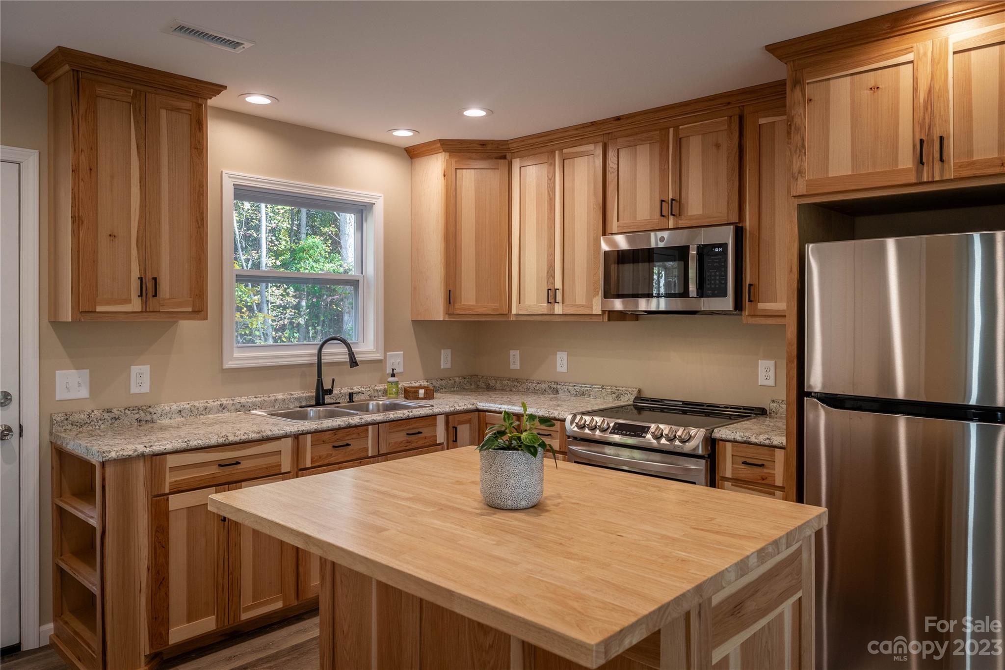 1237 Coffey Road Morganton, NC 28655 - Photo 5 of 19 a kitchen with a refrigerator a stove a sink a cabinets and wooden floor