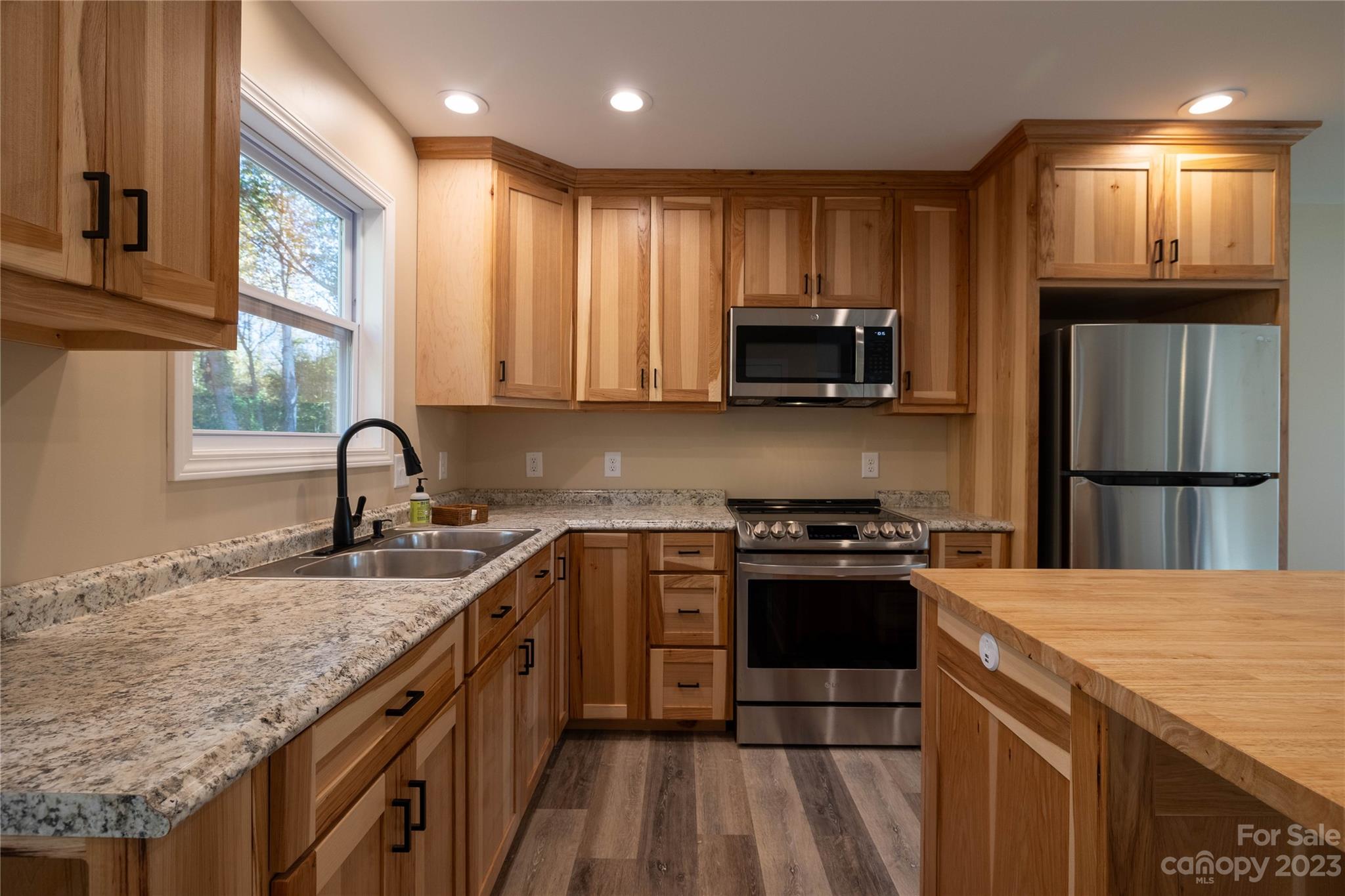 1237 Coffey Road Morganton, NC 28655 - Photo 6 of 19 a kitchen with granite countertop a sink stove and refrigerator