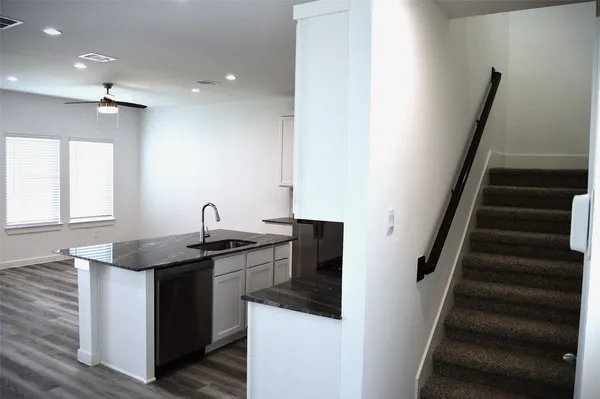a kitchen with granite countertop a sink and cabinets