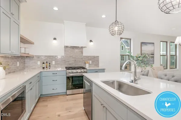 a large kitchen with granite countertop a sink a stove and cabinets