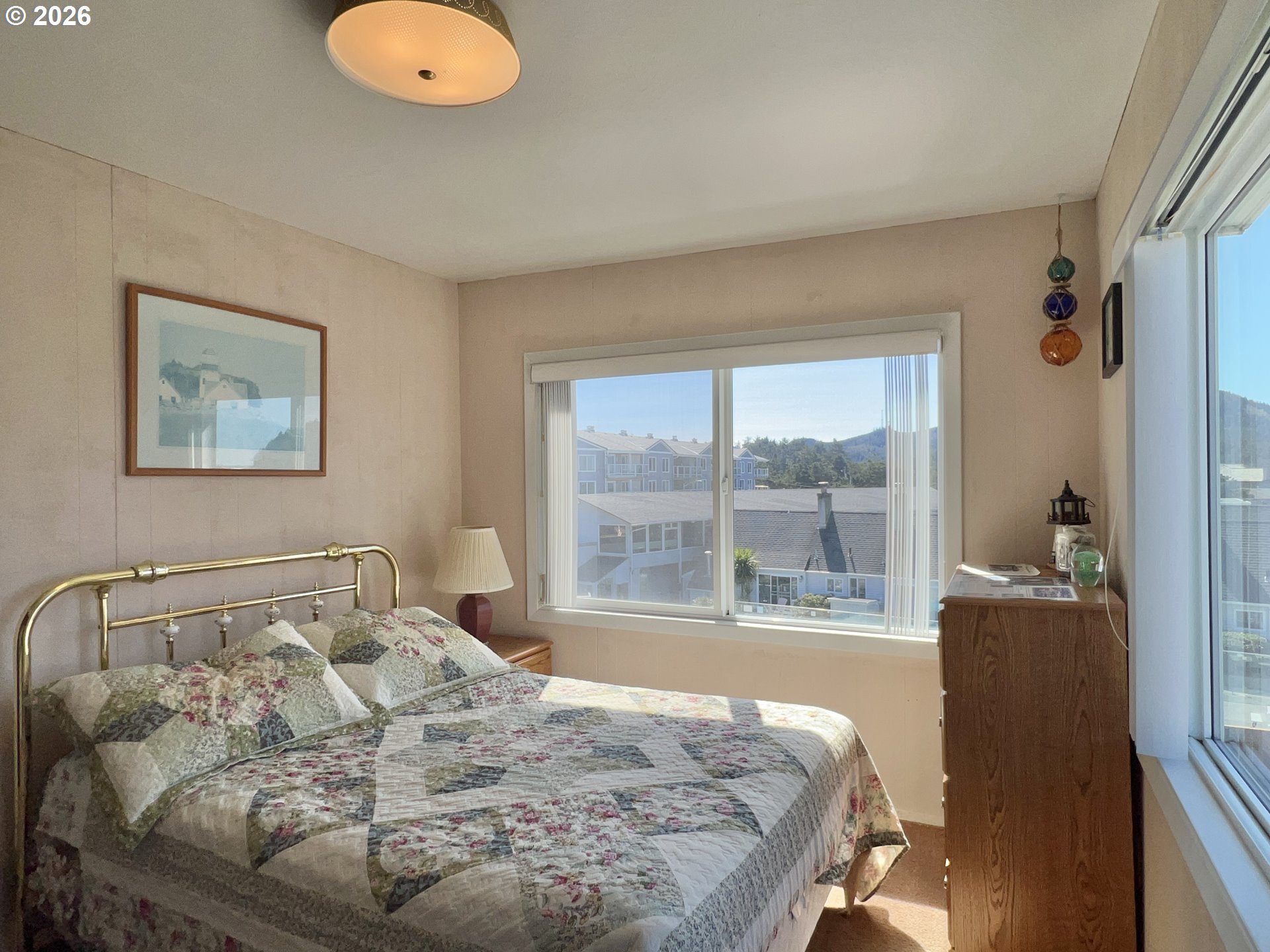 40 Avenue U, Unit 63 Seaside, OR 97138 - Photo 21 of 45 a bedroom with a bed and glass window