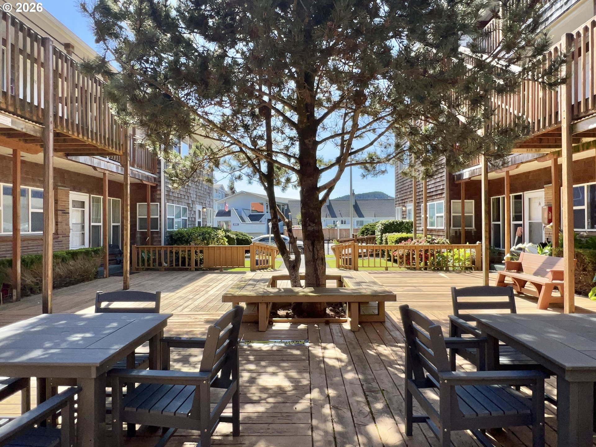 40 Avenue U, Unit 63 Seaside, OR 97138 - Photo 37 of 45 a view of a patio with couches table and chairs with wooden floor and fence