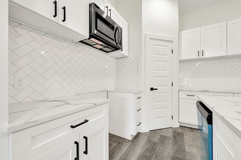 7922 Sealey Street Houston, TX 77088 - Photo 16 of 16 a kitchen with white cabinets and appliances