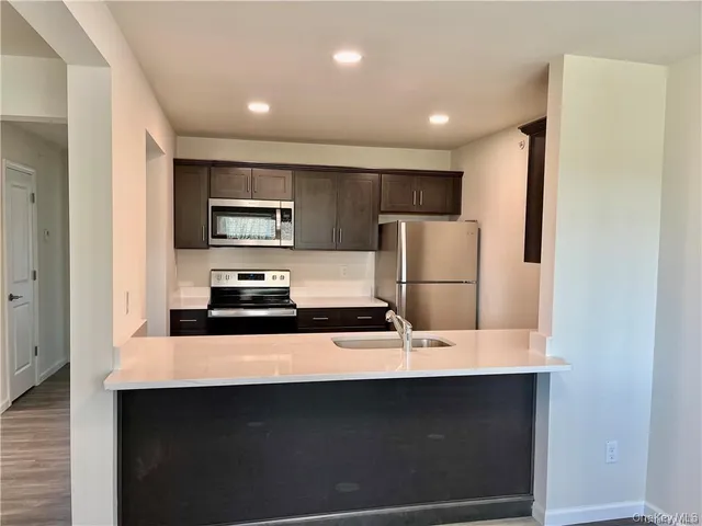 a kitchen with stainless steel appliances a refrigerator a sink a stove a microwave and island