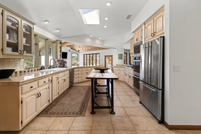 a kitchen with stainless steel appliances granite countertop a refrigerator and a sink