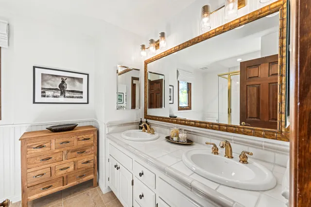a bathroom with double vanity sinks and a mirror