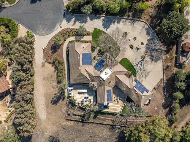 an aerial view of a house with a mountain