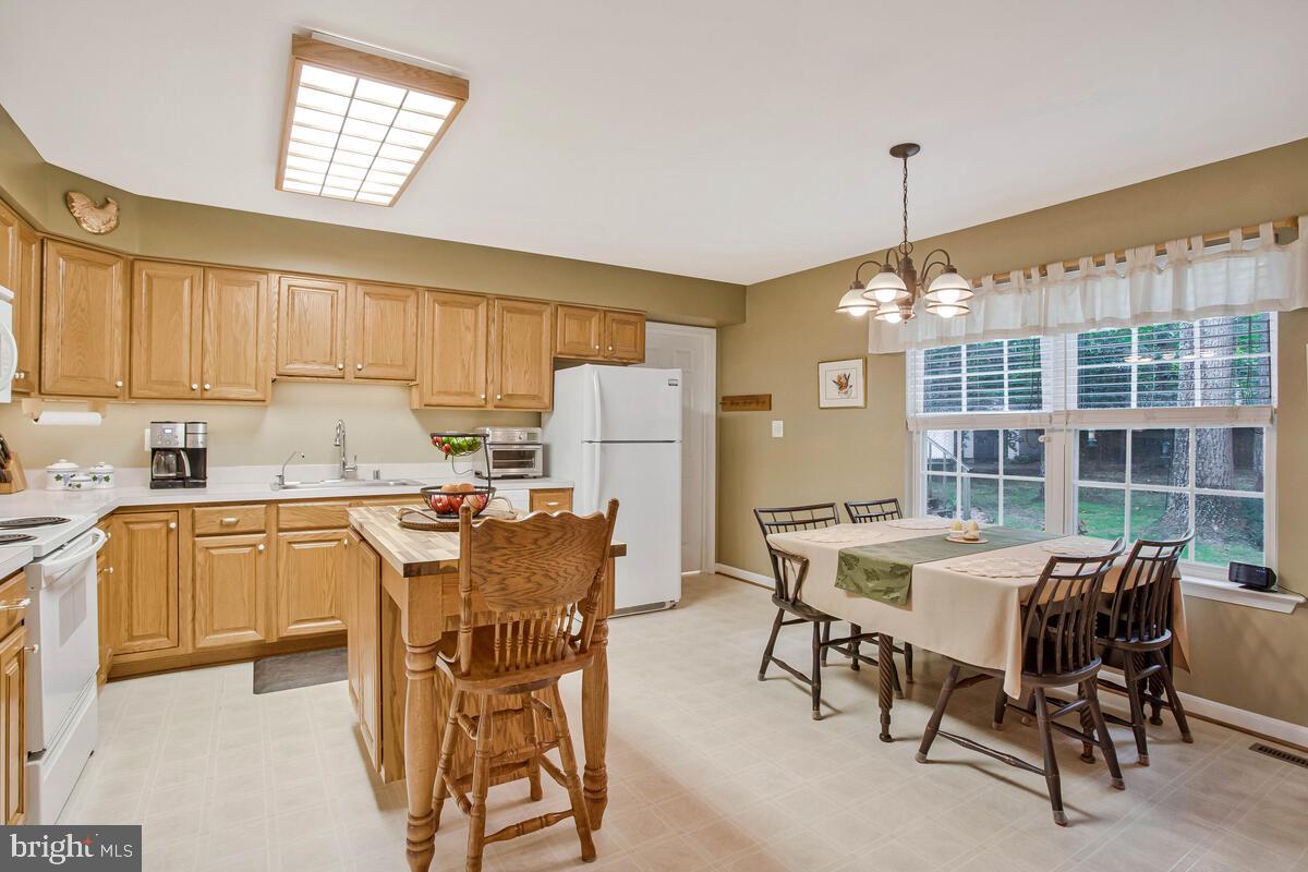 1805 Rudolph Lane Lusby, MD 20657 - Photo 7 of 43 a kitchen with a table chairs and a refrigerator