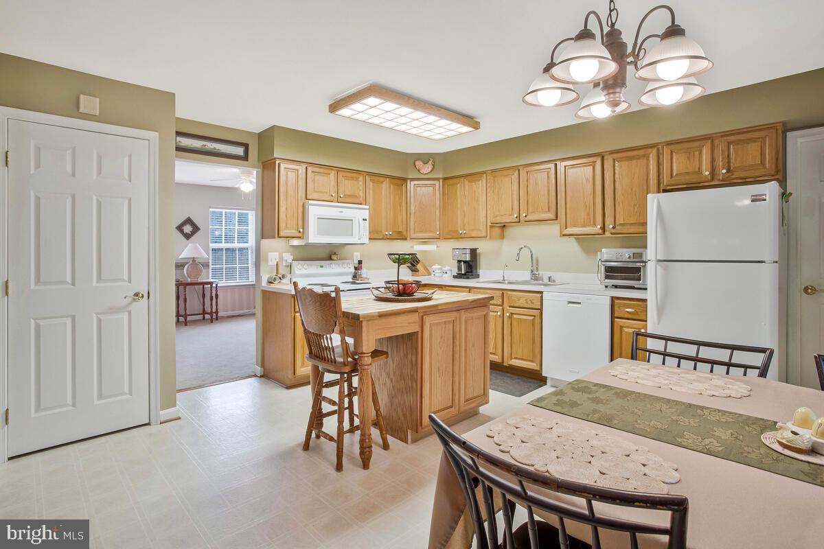 1805 Rudolph Lane Lusby, MD 20657 - Photo 8 of 43 a kitchen with a table chairs refrigerator and cabinets
