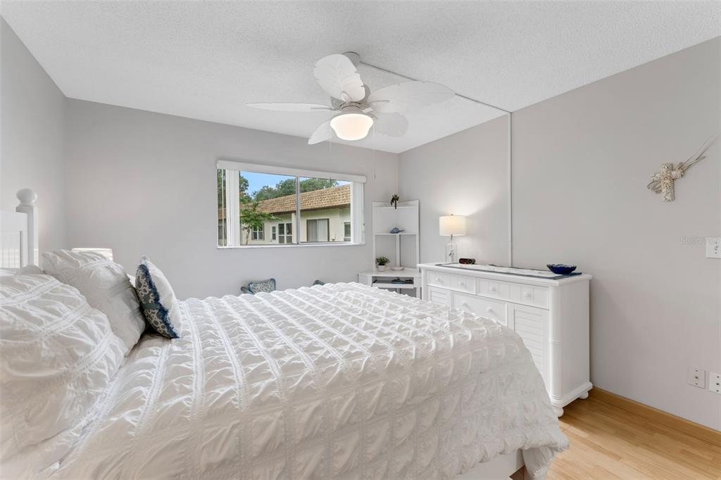 3140 Highlands Boulevard, Unit F Palm Harbor, FL 34684 - Photo 15 of 78 a bedroom with a bed and a chandelier