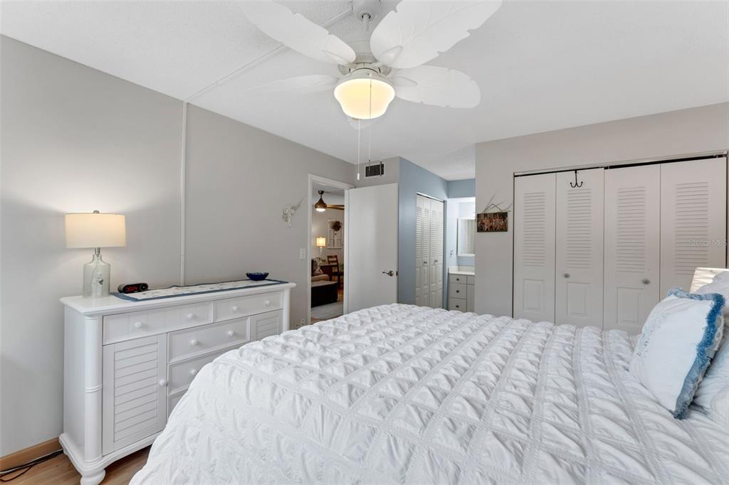 3140 Highlands Boulevard, Unit F Palm Harbor, FL 34684 - Photo 16 of 78 a spacious bedroom with a bed and a chandelier