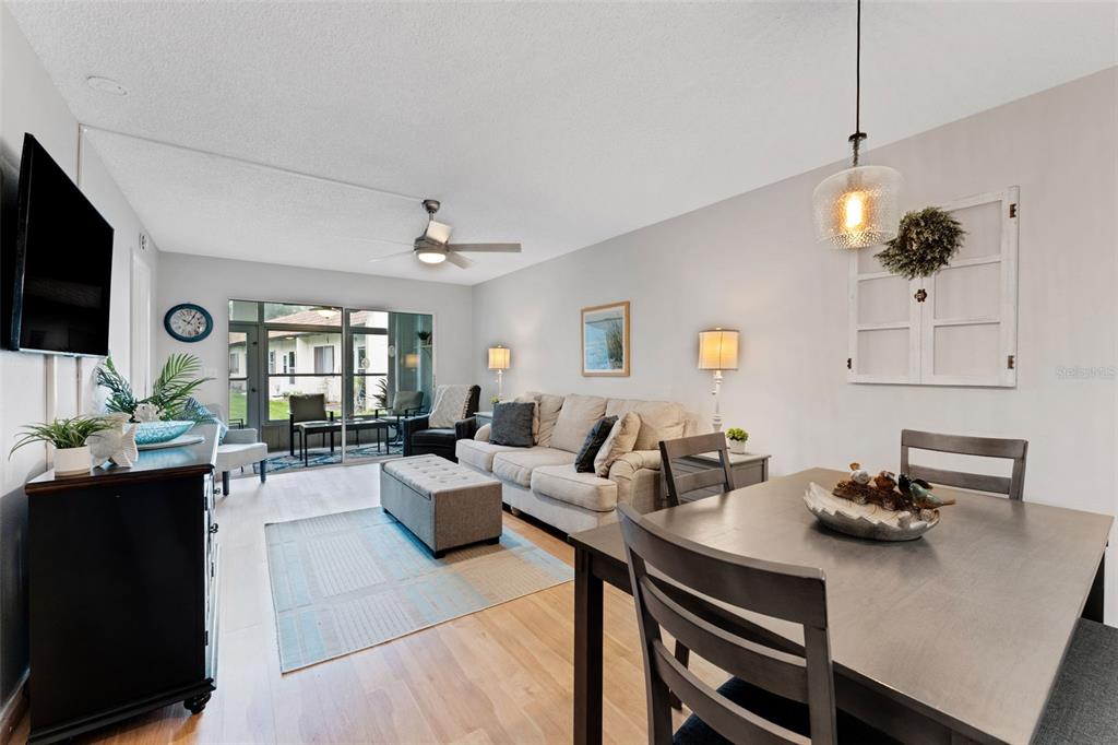 3140 Highlands Boulevard, Unit F Palm Harbor, FL 34684 - Photo 2 of 78 a living room with furniture a flat screen tv and kitchen view