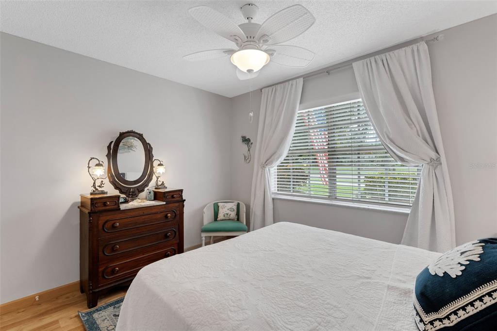 3140 Highlands Boulevard, Unit F Palm Harbor, FL 34684 - Photo 23 of 78 a bedroom with a bed a dresser and a potted plant